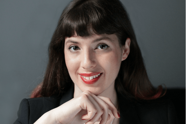 Karen Elazari smiling at the camera in a black blazer