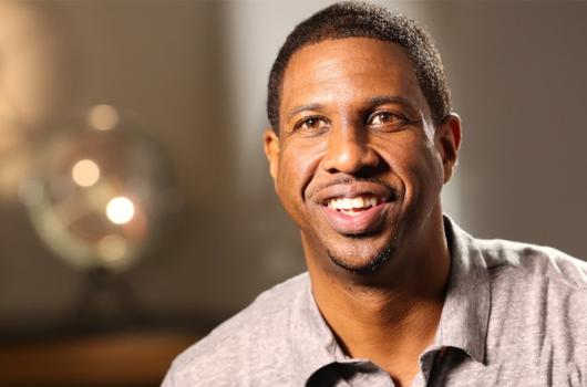 hakeem oluseyi in a grey collared shirt, smiling