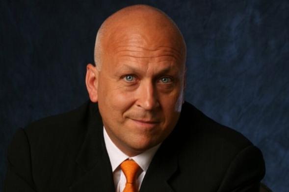 cal ripken poses in front of a blue background