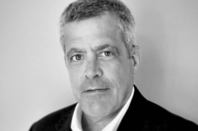 ted singer pictured against a grey background in black and white