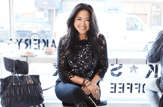 lisa sun seated and smiling positioned in front of a window