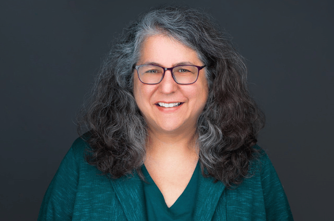 linda weissgold pictured against a dark grey background smiling