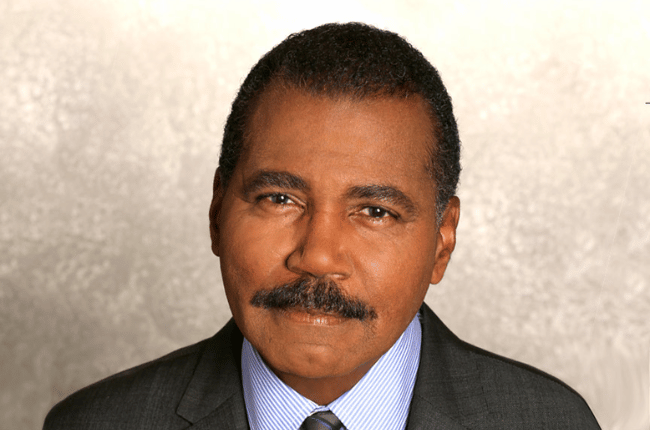 bill whitaker pictured against a beige background.